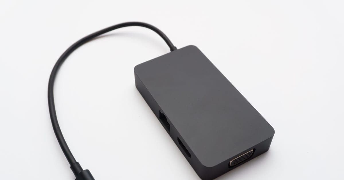 A USB-C hub with several ports and a captive cable, on a white surface